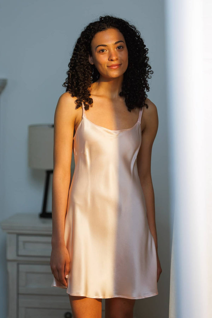 Petal pink silk slip dress with thin straps and a smooth, flowing texture.
