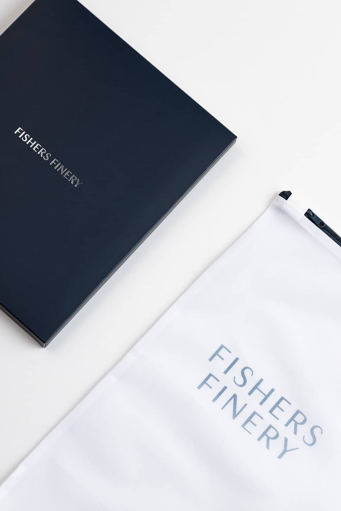 White silk fabric pouch with navy blue Fishers Finery logo and matching navy box.