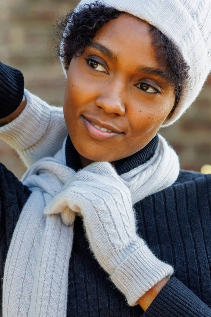 Stone silk knit gloves with ribbed texture and matching headband worn by person.