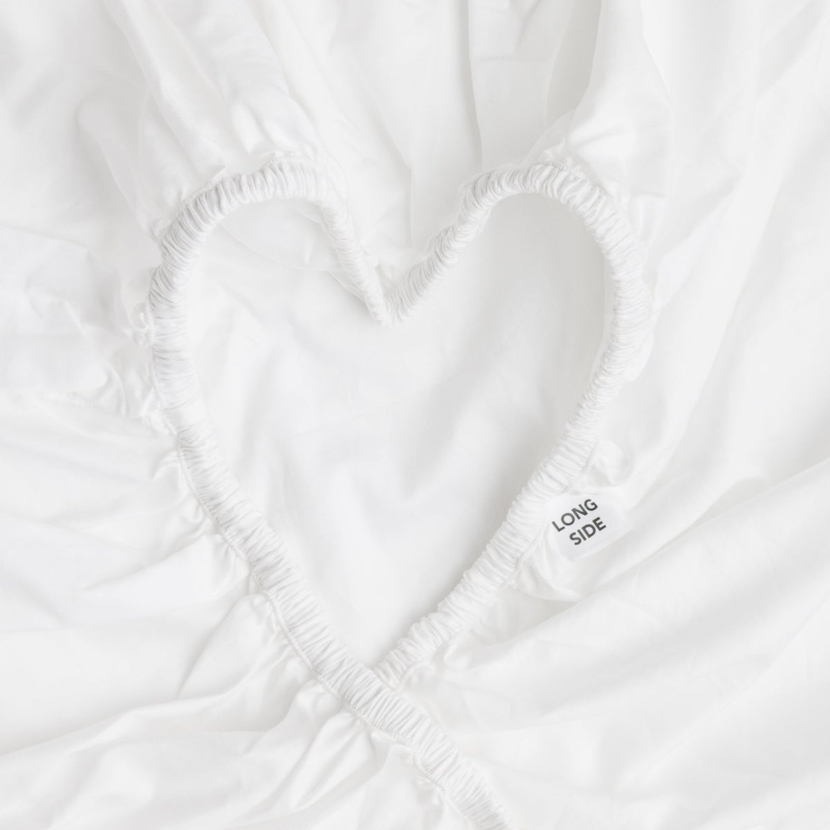 Fitted sheet elastic shaped into a heart, showing the Long Side label