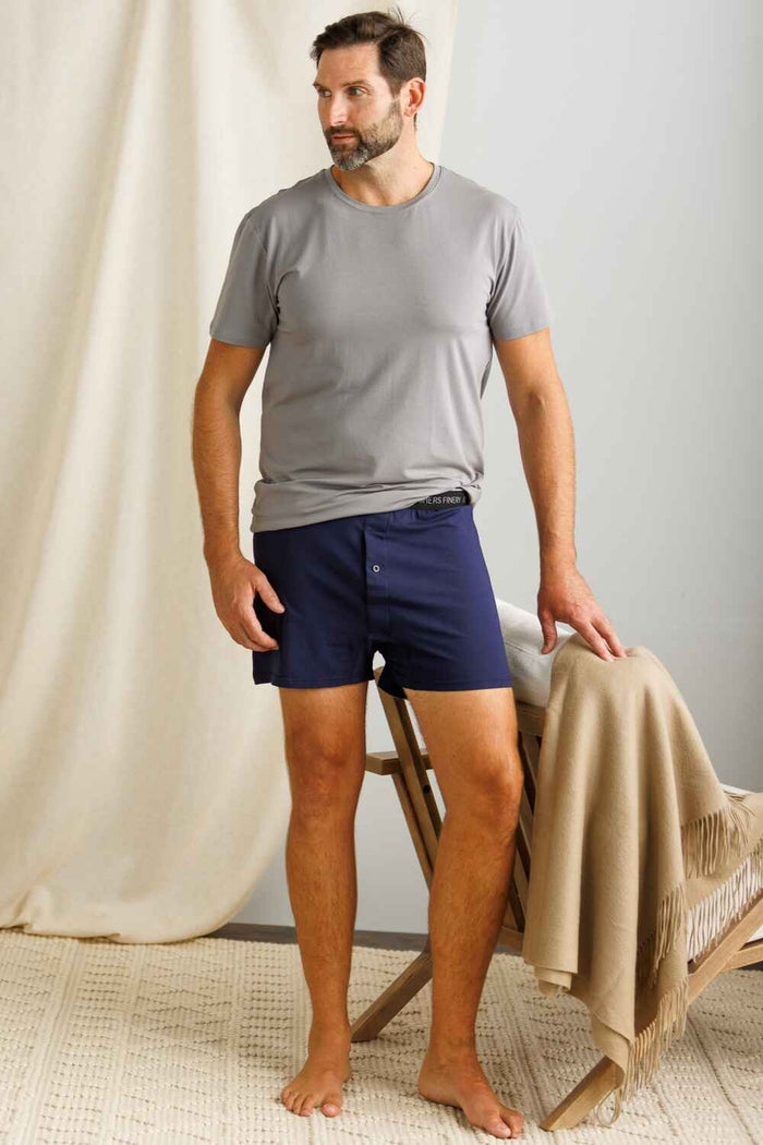 Gray silk short-sleeve shirt paired with navy silk shorts on a standing male model.