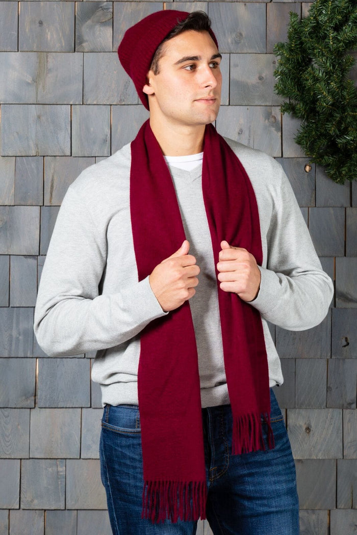 Deep cabernet silk scarf with fringed edges worn with a gray long-sleeve shirt and matching beanie.