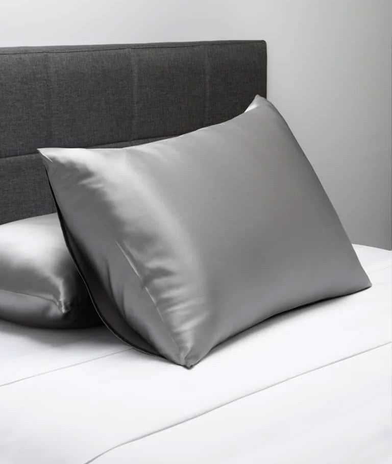 Gray silk pillowcases on a made bed