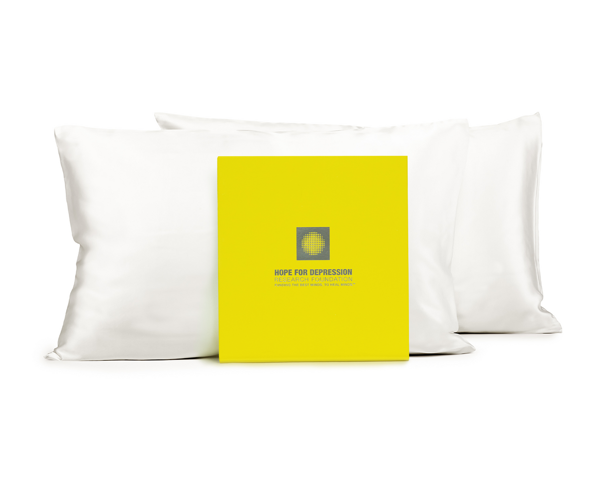 White silk pillowcases displayed with Hope for Depression Research Foundation packaging.