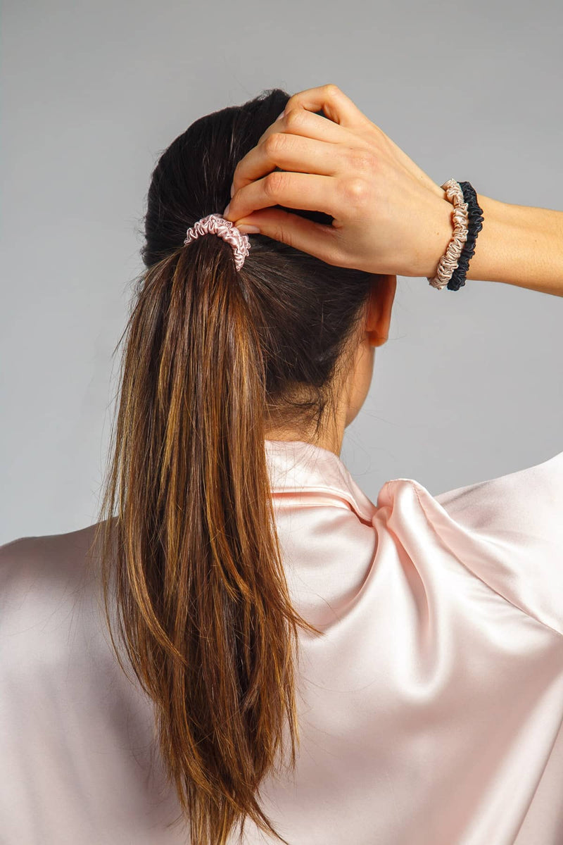 Pink-taupe-black silk scrunchie holding long brown hair in a ponytail.