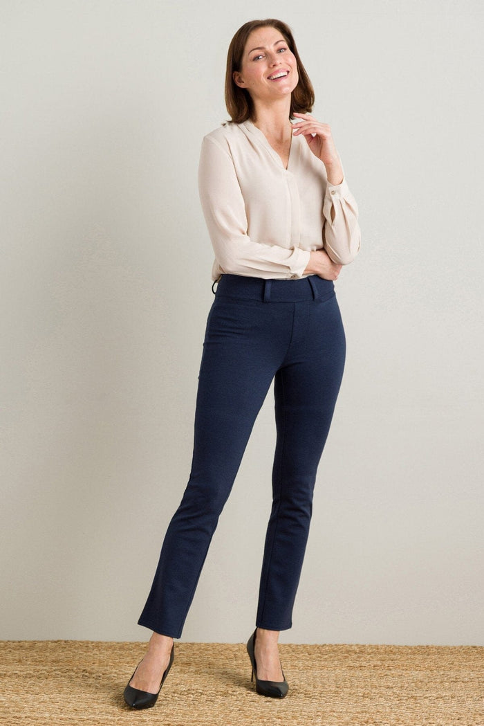 Light beige silk blouse with long sleeves and buttoned cuffs paired with navy slim-fit ankle pants and black heels.