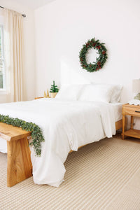 bedroom with white duvet set with a holiday decorated room