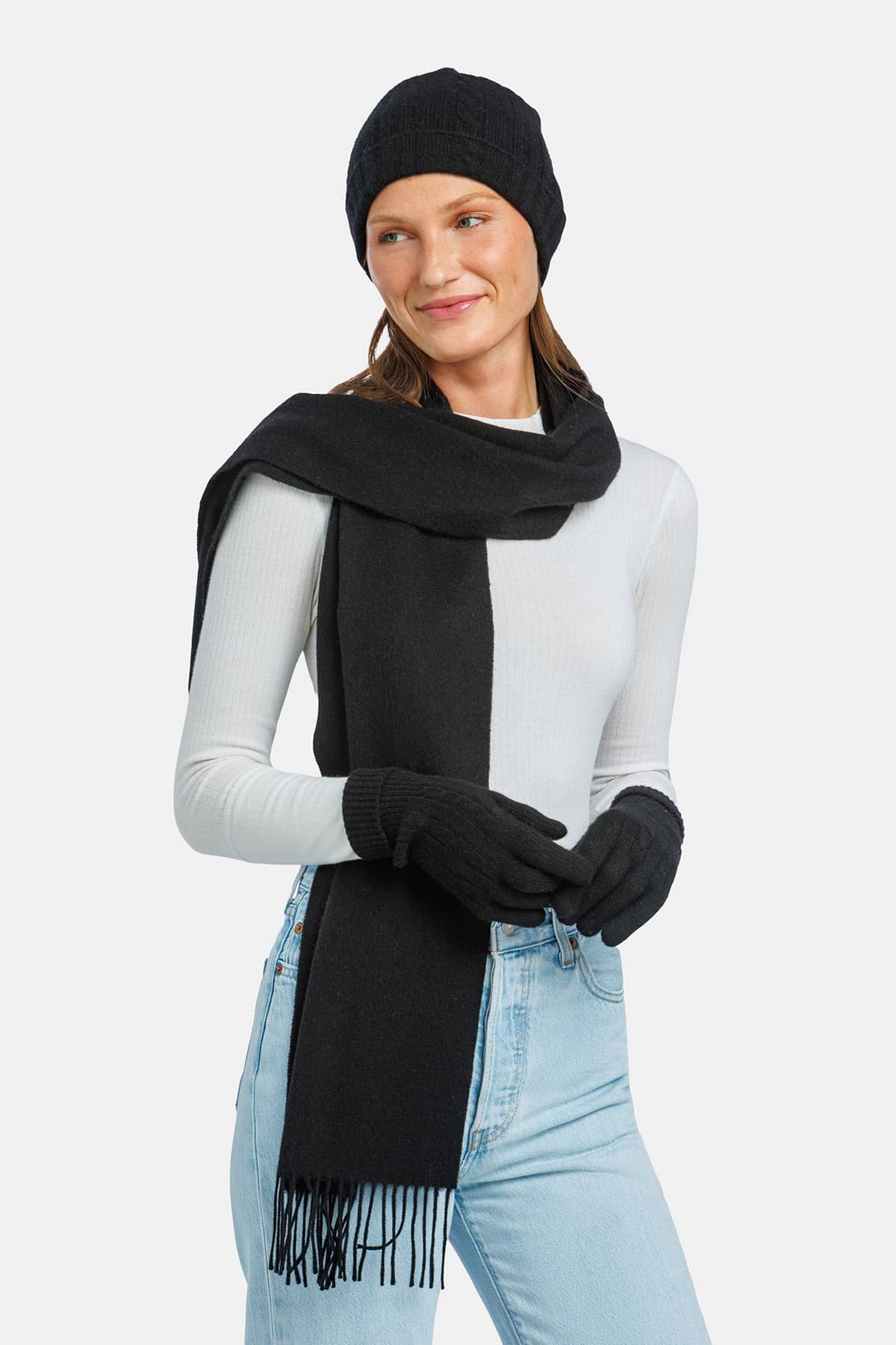 women wearing black cashmere hat glove and scarf set over a white top and jeans