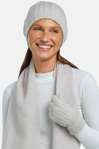 women wearing a light gray cashmere hat glove and scarf set over a white top