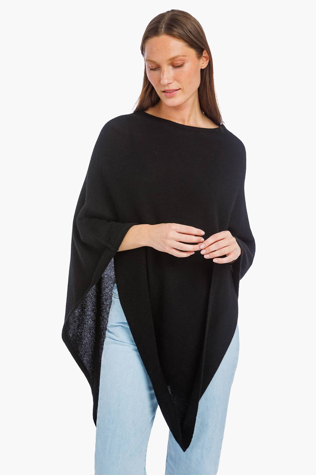 women wearing a black cashmere poncho over jeans.
