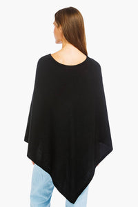 women wearing a black cashmere poncho over jeans back view