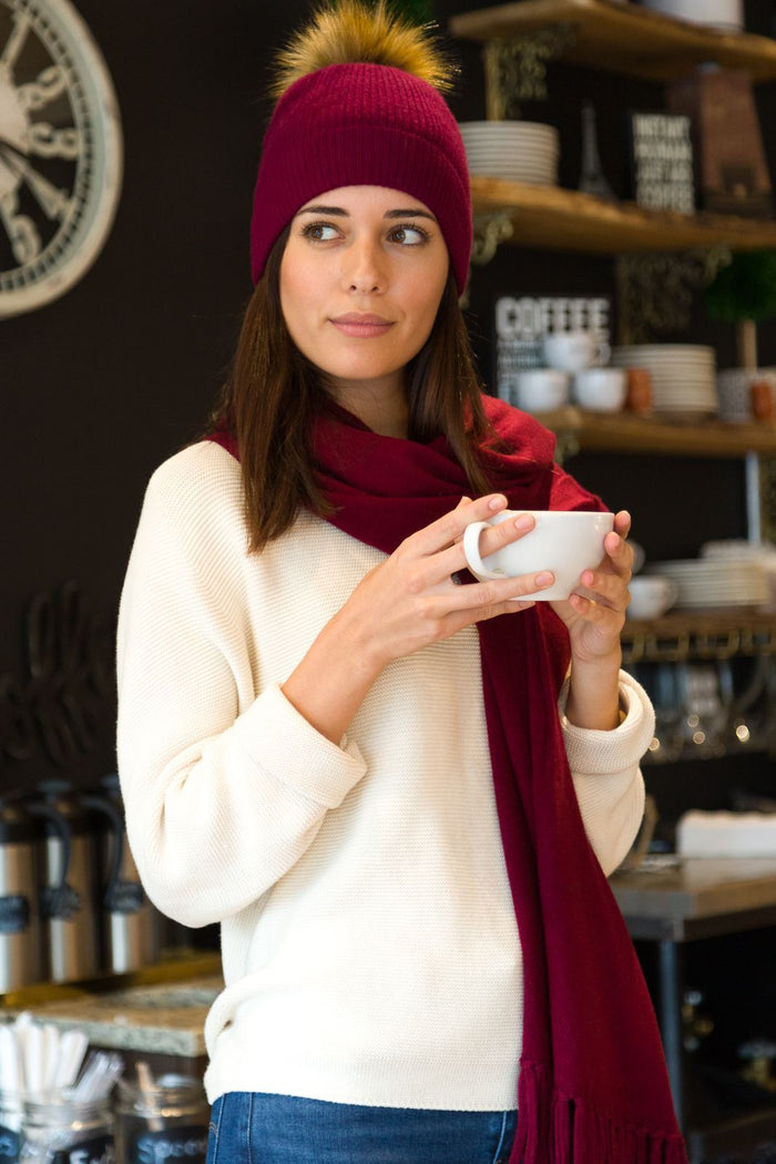 Burgundy silk scarf and matching beanie with pom-pom worn with ivory sweater.