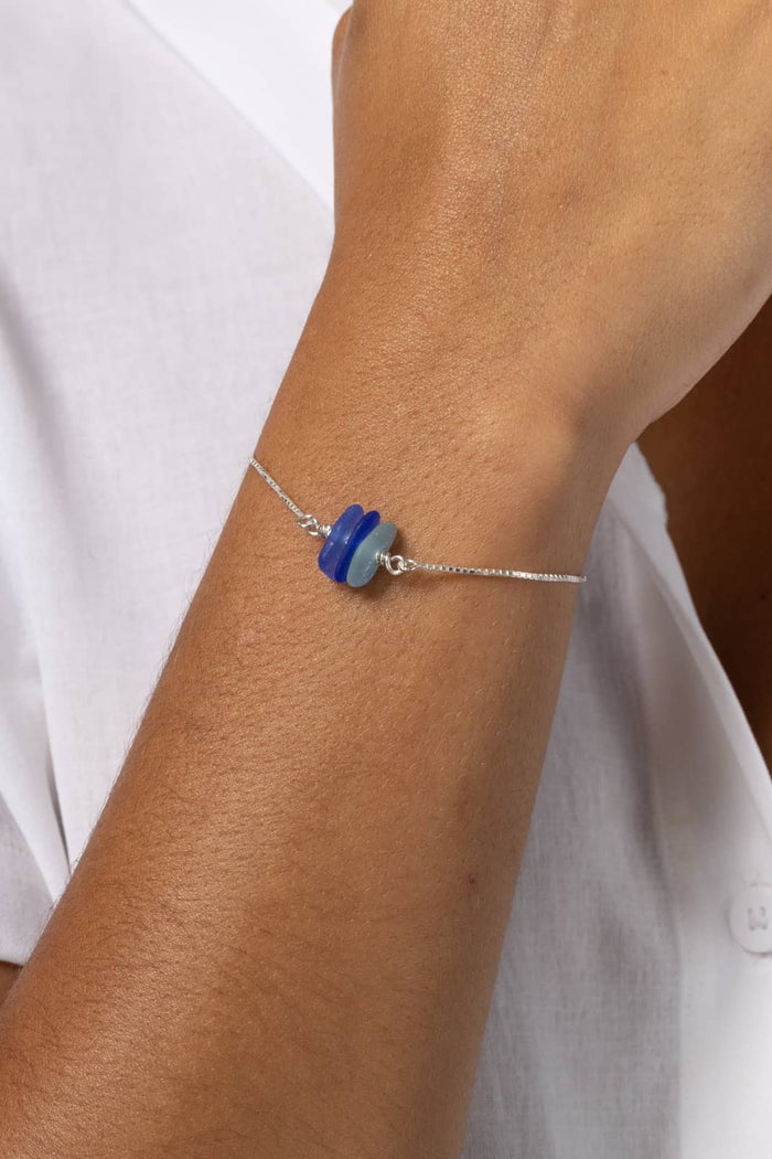 Delicate silk thread bracelet with layered blue and sky beads on wrist.