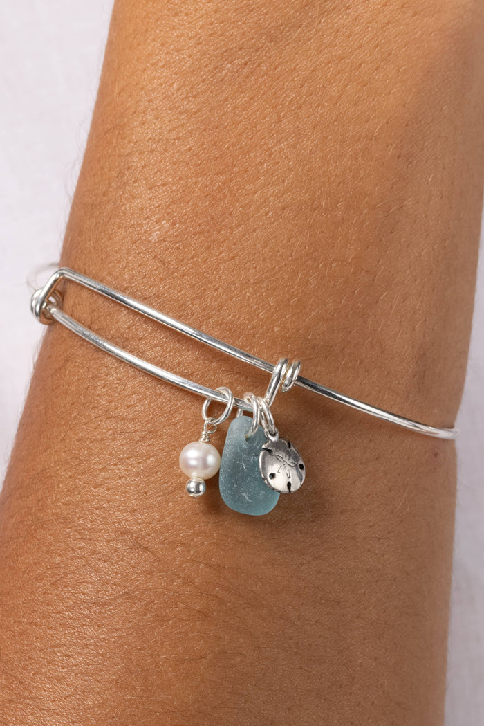 Silver bangle with silk teardrop charm and small pearl accent.