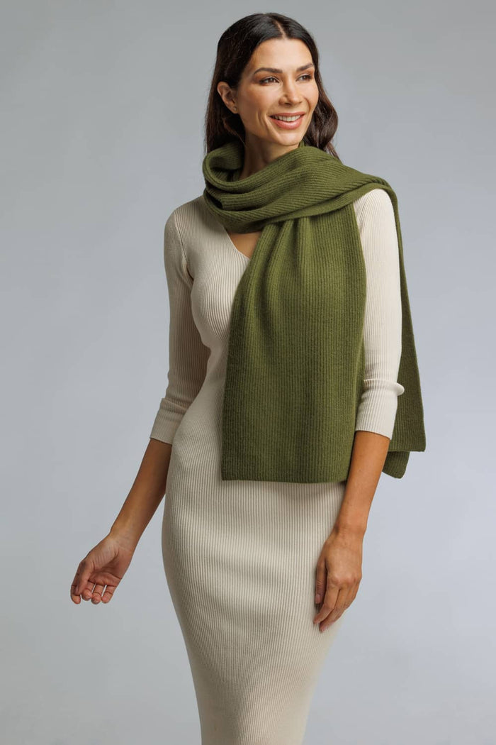 Olive green silk scarf draped over cream fitted dress on smiling woman.